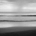 Black and white photograph of the ocean with waves rolling in